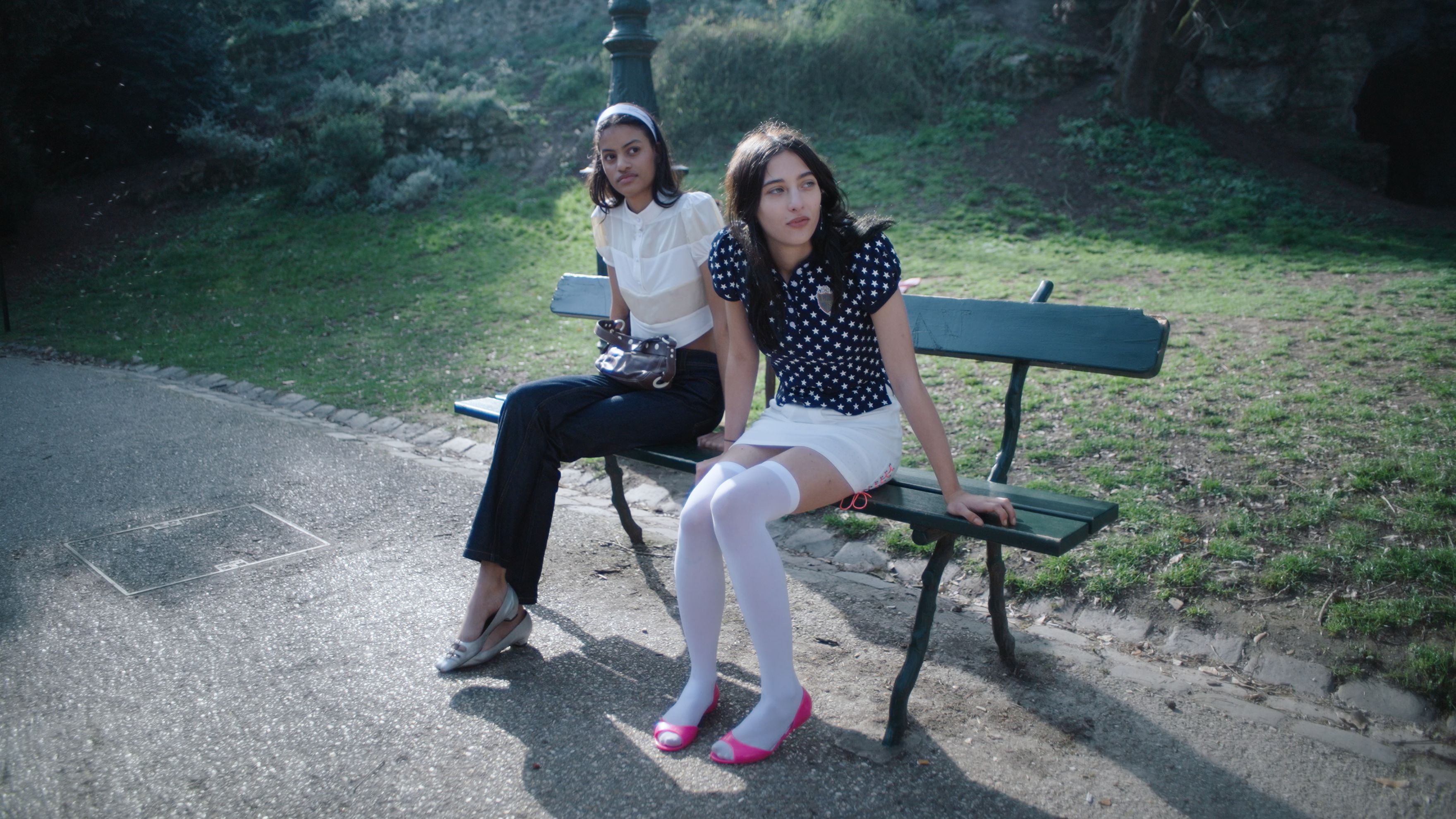 Two women sitting on a bench in a park